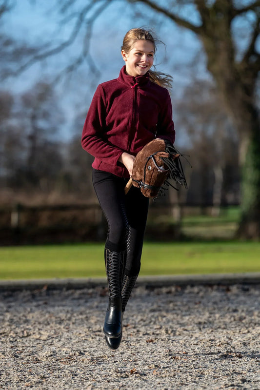 Mädchen galoppiert mit braunem Hobby Horse