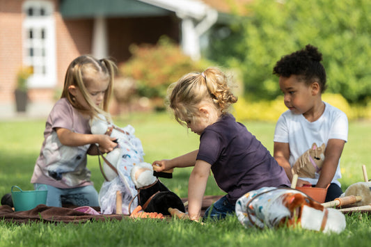 Kinder putzen ihre Hobby Horses mit Putzzeug