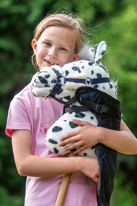 Mädchen umarmt ihr Hobby Horse mit Halfter – liebevoller Moment mit Steckenpferd