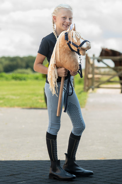 Mädchen zeigt stolz ihr Hobby Horse mit Halfter und Strick