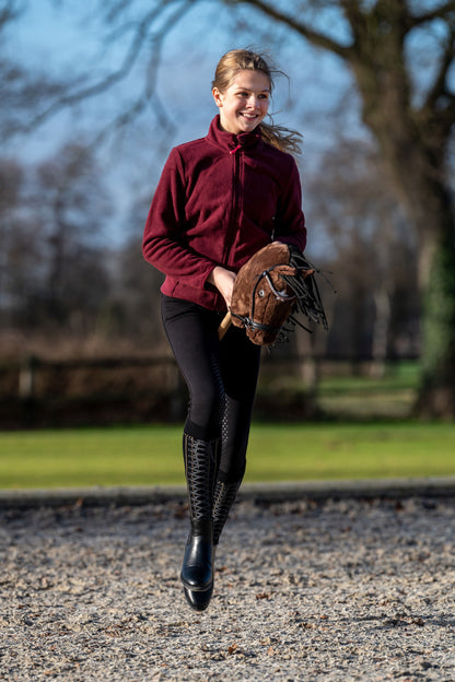 Mädchen galoppiert mit braunem Hobby Horse