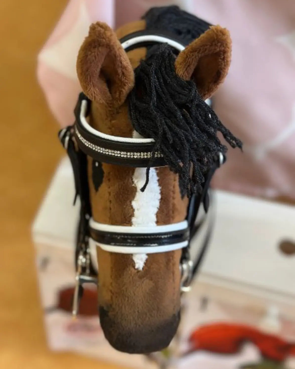 Professioneller Dressur-Look für kleine Hobby Horses: Die schwarze LeMieux Dressurkandare mit funkelndem Glitzerstirnriemen perfekt angepasst an ein braunes Steckenpferd mit weißer Blesse.