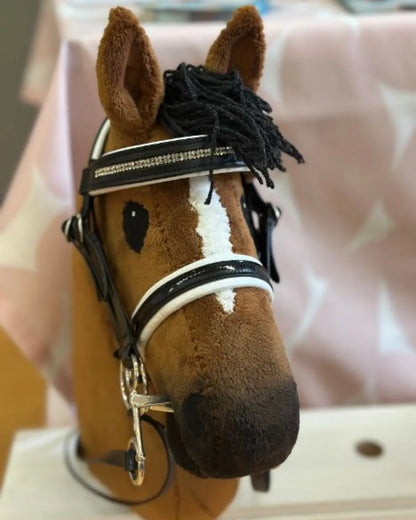 Hobby Horsing Dressur Zubehör für ambitionierte Reiter: Frontalansicht des exklusiven LeMieux Kopfstücks mit Doppelzügeln an einem braunen Dressur-Steckenpferd.