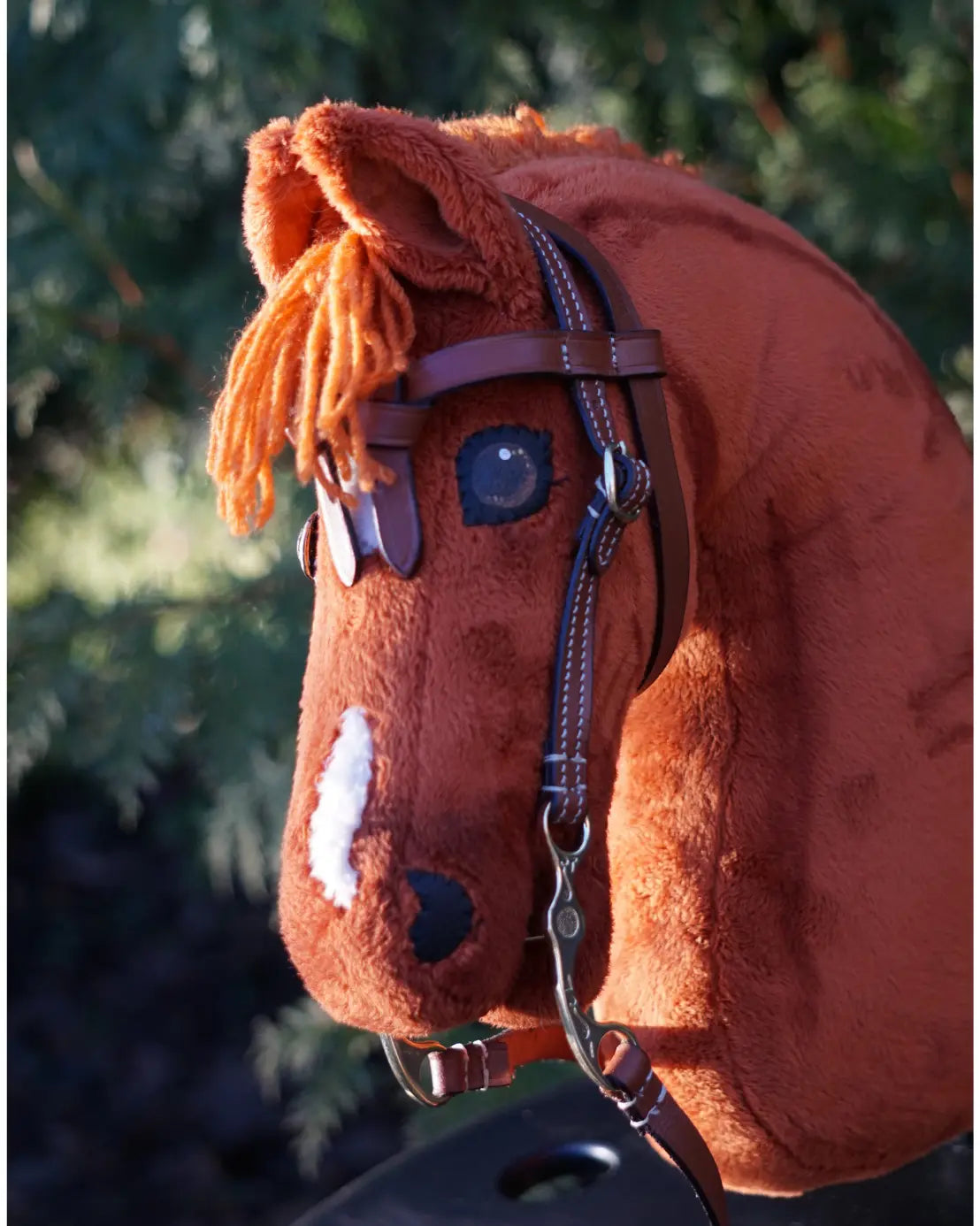Authentischer Western-Look für kleine Hobby Horses: Das schwarze LeMieux Westernzaumzeug mit geknotetem Stirnriemen perfekt angepasst an ein braunes Steckenpferd.