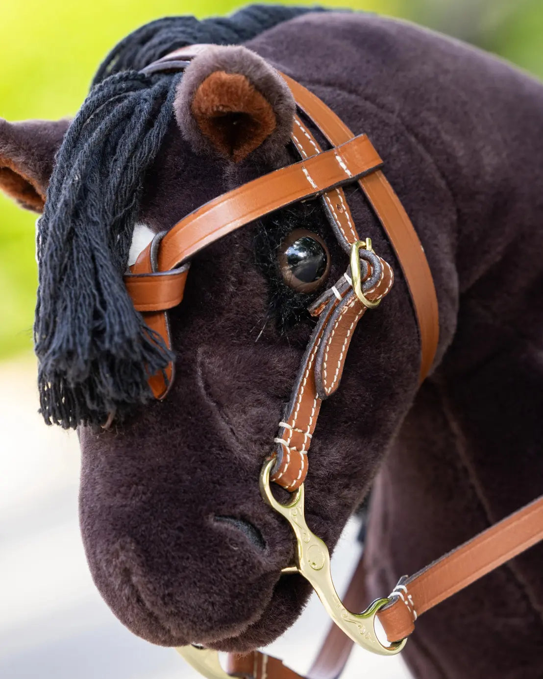 Kreatives Western-Rollenspiel im Hobby Horsing Sport: Hochwertig verarbeitete braune LeMieux Westerntrense in Größe S an einem dunkelbraunen Steckenpferd.