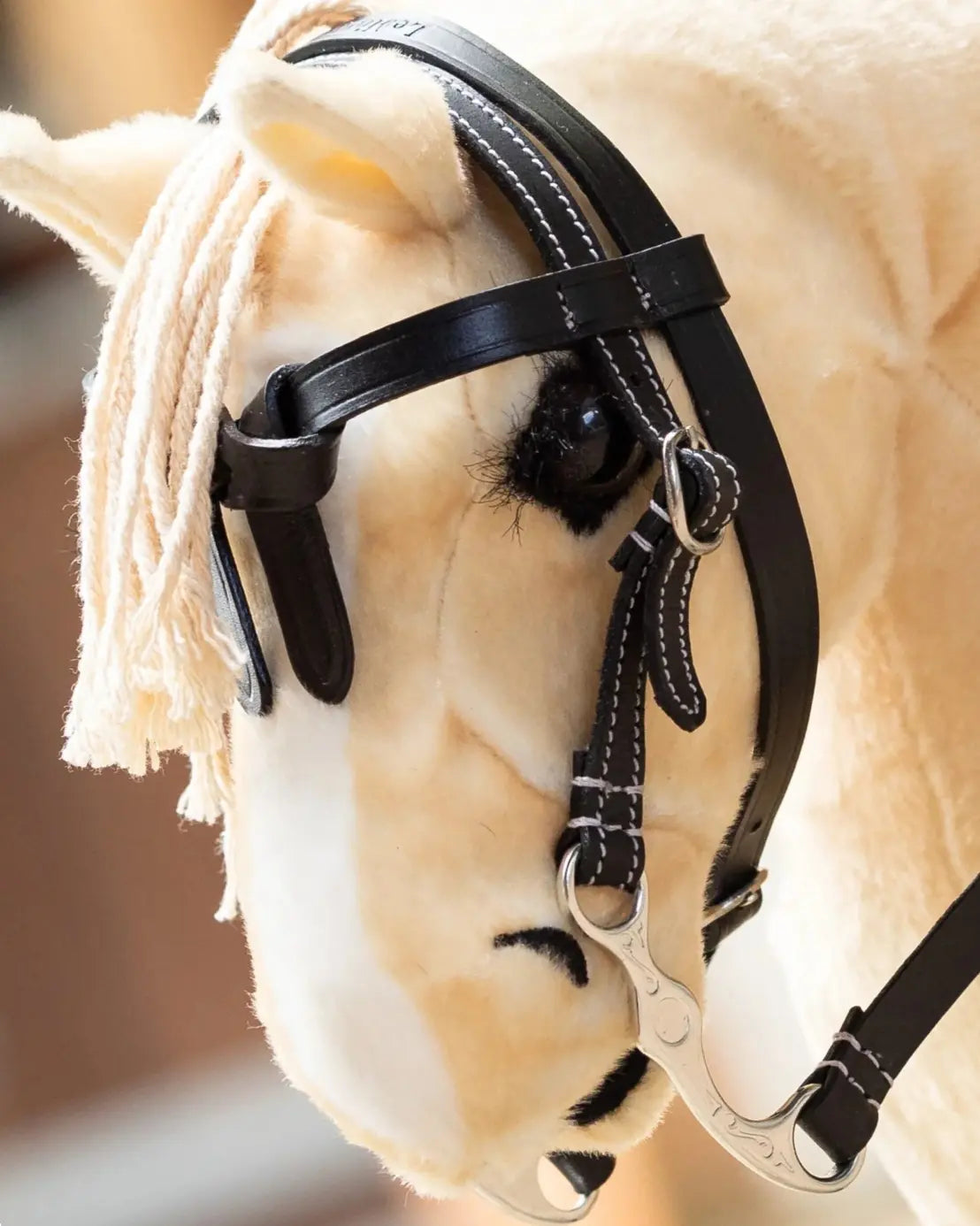 Hobby Horsing Westernreiten Zubehör: Detailansicht der verstellbaren LeMieux Westerntrense aus schwarzem Leder an einem hellen Palomino Hobby Horse.