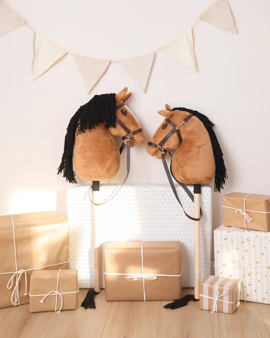 Bieco Hobby Horse als Geschenkidee neben Paketen unter einer Wimpelkette; perfekt für Geburtstage und Hobby Horsing Fans