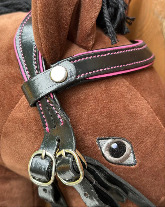 Verstellbare HKM Hobby Horsing Trense aus echtem Leder: Detailansicht der Schnallen und des austauschbaren Stirnbands mit pinken Ziernähten.