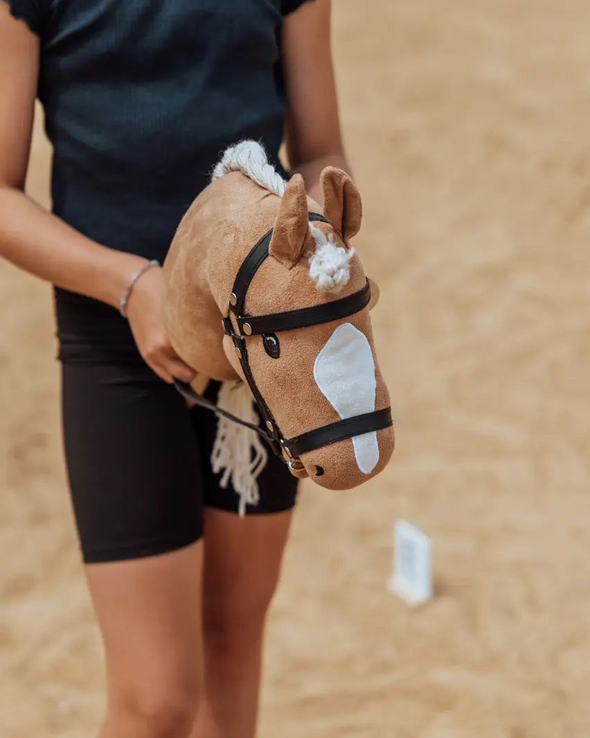 Realistisches Spielzubehör für kleine Reiter: Detailansicht des byASTRUP Hobby Horses „Beauty“ mit Blesse und Lederzaumzeug beim aktiven Bewegungssport.