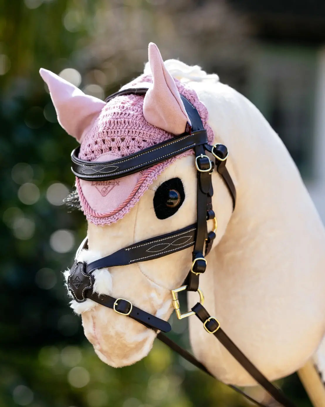 Harmonisches Hobby Horsing Outfit-Set: Ein Palomino Steckenpferd trägt die blassrosa LeMieux Fliegenhaube Blossom – maschinenwaschbar und ideal für tägliche Rollenspiele und hobby horse Turniere