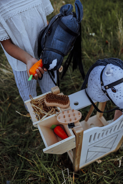 Kinder füttern und pflegen ihre Steckenpferde im stabilen byASTRUP Hobby Horse Stall – ideal für langlebigen Spielspaß.