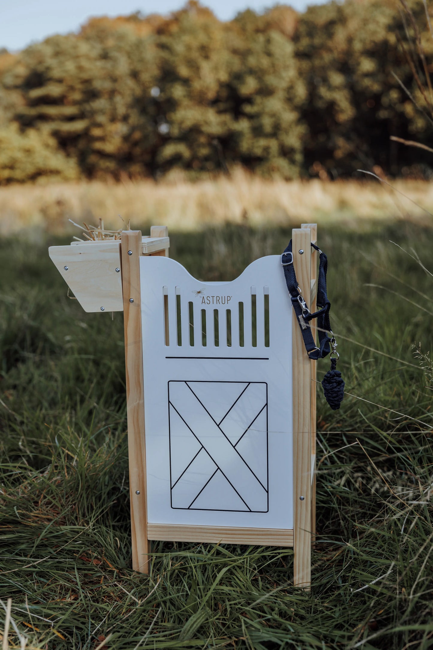 Der byASTRUP Holzstall für 2 Hobby Horses im skandinavischen Design, aufgebaut für das kreative Outdoorspiel auf einer Wiese.