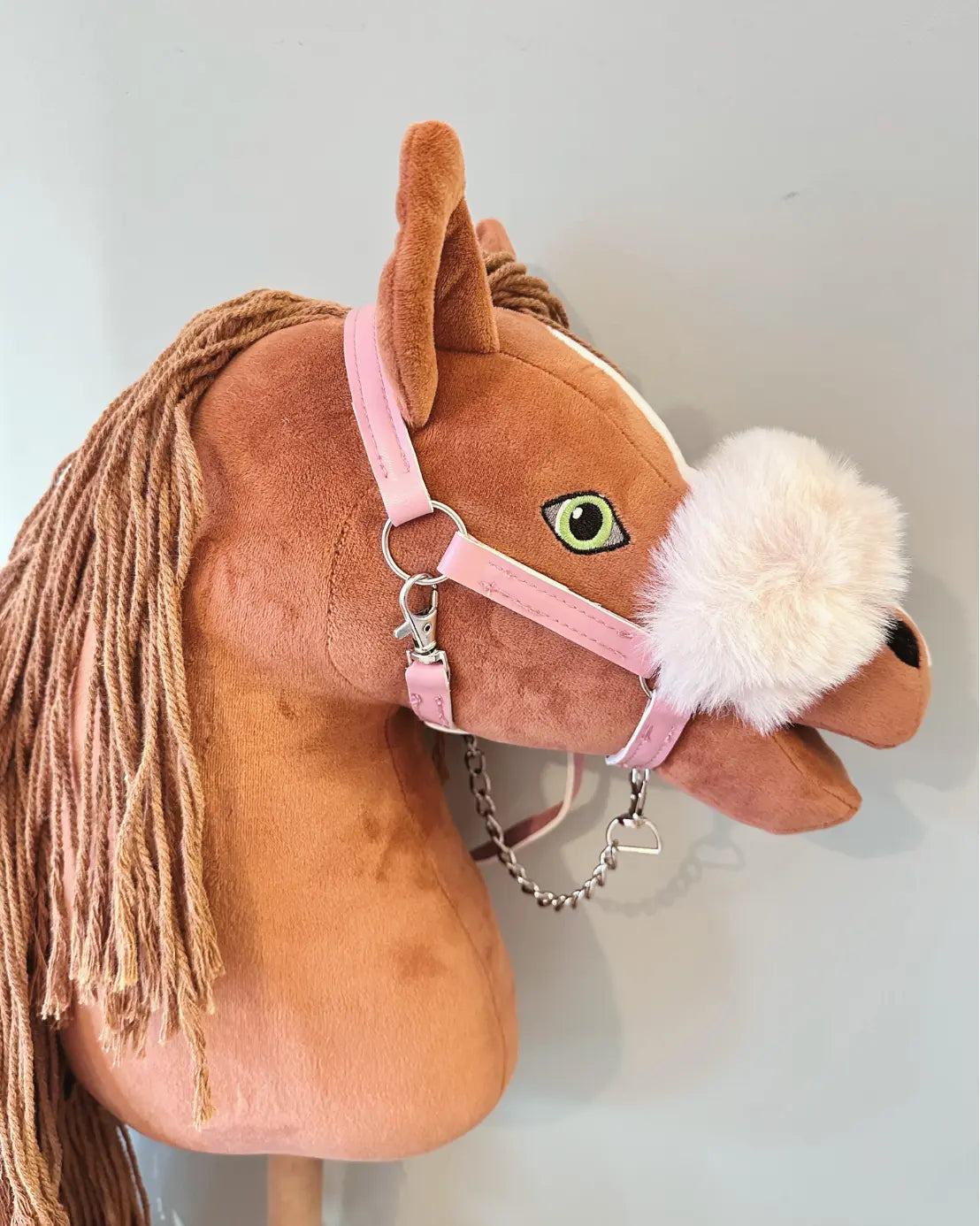 Hobby Horse Halfter in rosa mit Führkette in rosa am Kopf eines fuchsfarbenen HKM Hobby Horses
