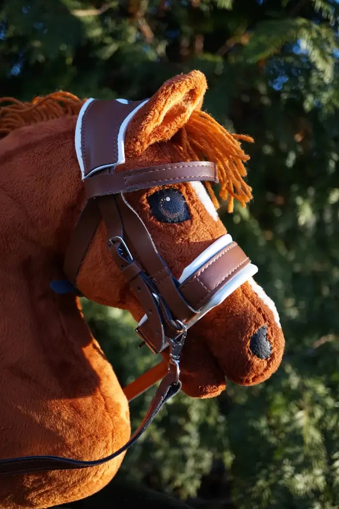 braune Panduro Hobby Horse  Turnier Trense an einem Hobby Horse in der Morgensonne